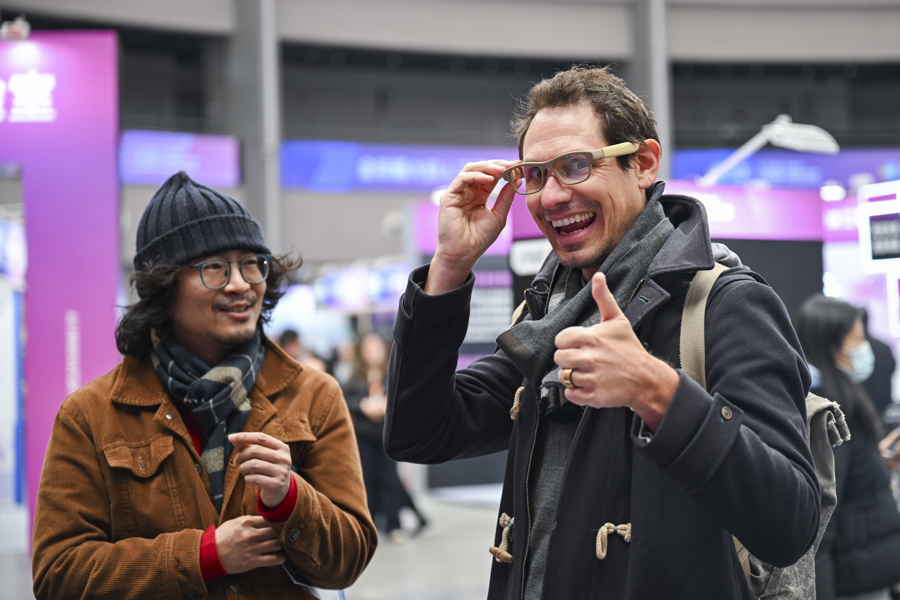 观众在全球开发者先锋大会体验智能眼镜。图源：GJ